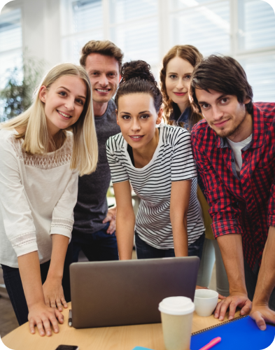 A team of individuals hire a virtual assistant, all gathered around a laptop.